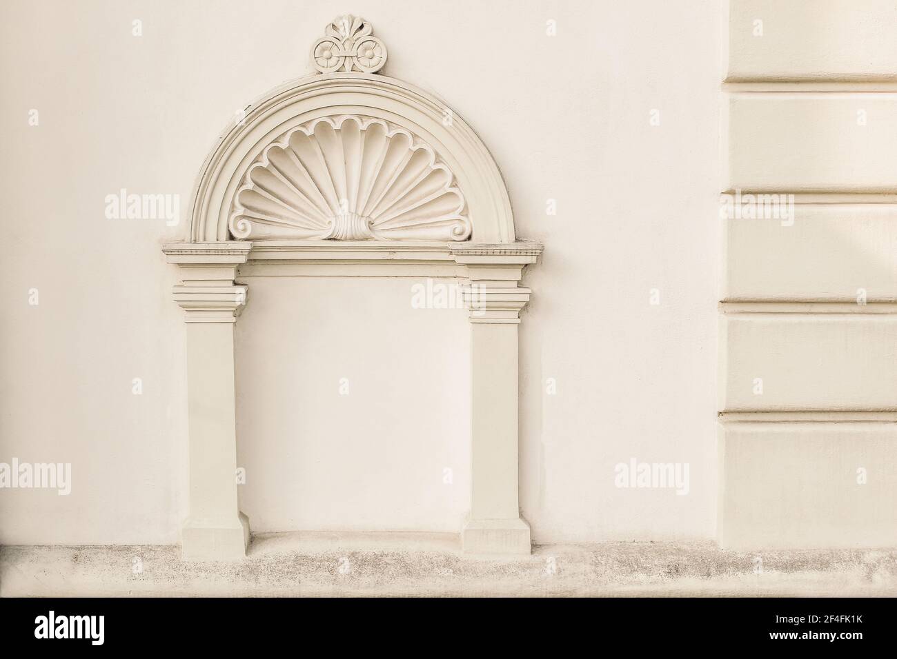 Dekorativer Bogen und Halbgewölbe über Nische mit klassischen Säulen. Architektonisches Stuckdetail des alten europäischen Gebäudes in Prag. Elegante gemauerte Fassade Stockfoto