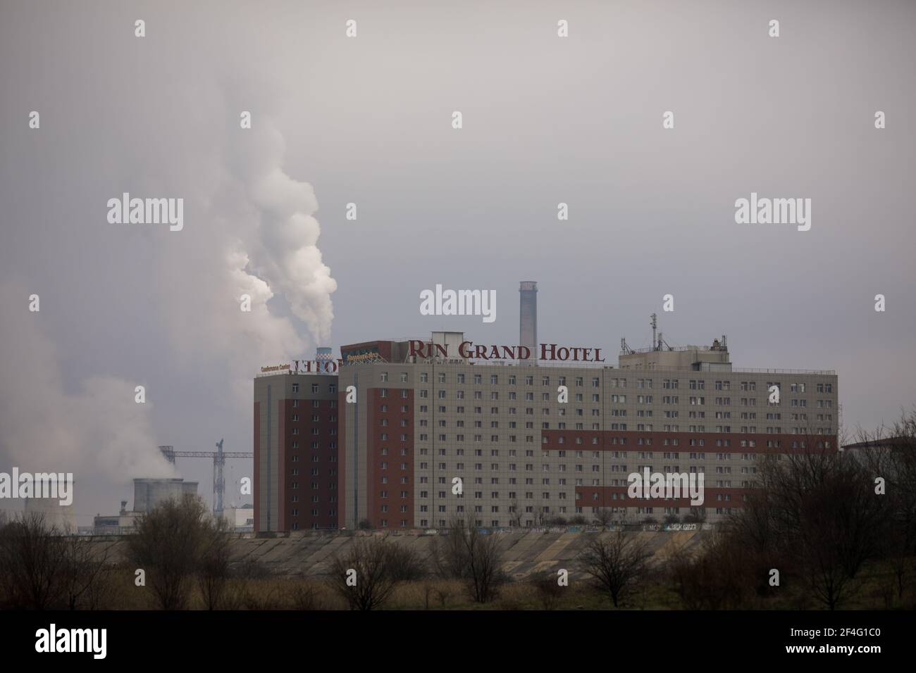 Bukarest, Rumänien - 20. März 2021: Rin Grand Hotel in Bukarest, mit einem rauchenden Kraftwerk im Hintergrund. Stockfoto