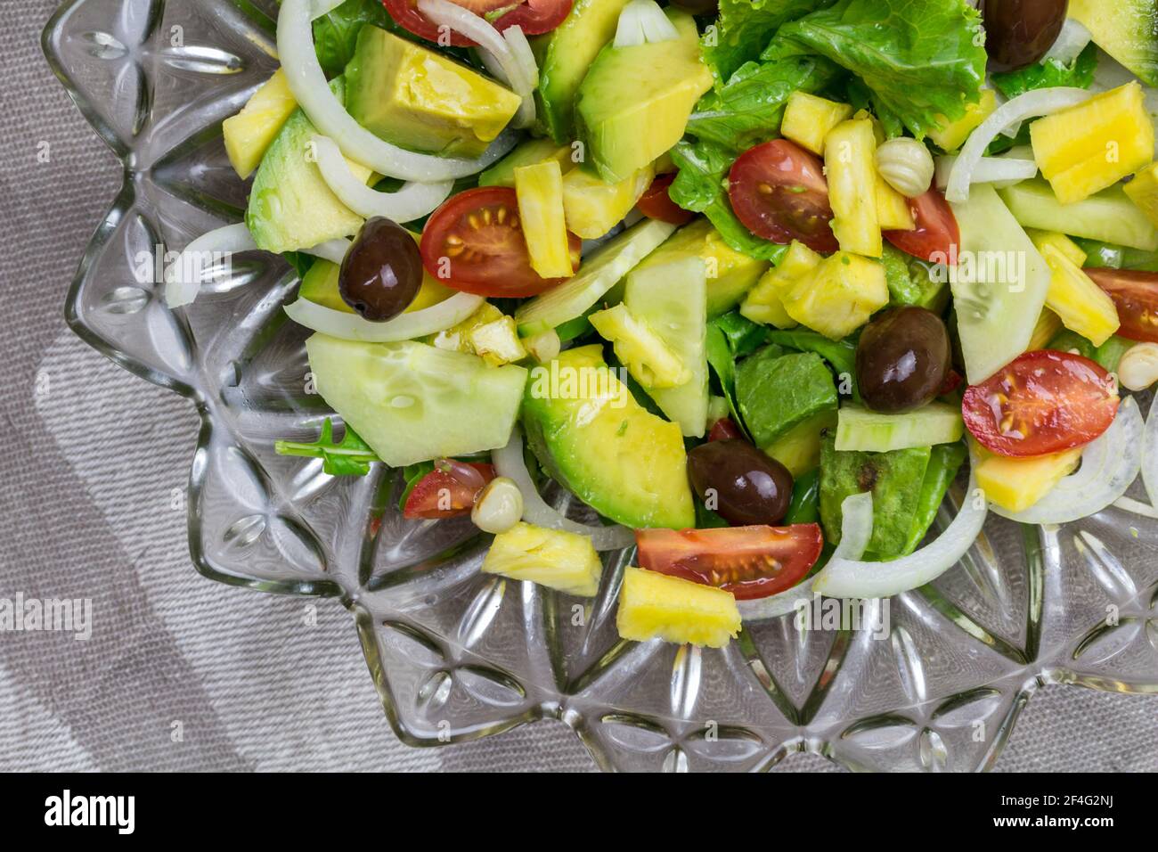 Frischer Gartensalat mit Tomaten, Salat, Avocado, Gurke, Ananas, Kapern und Oliven - Draufsicht Bild Stockfoto