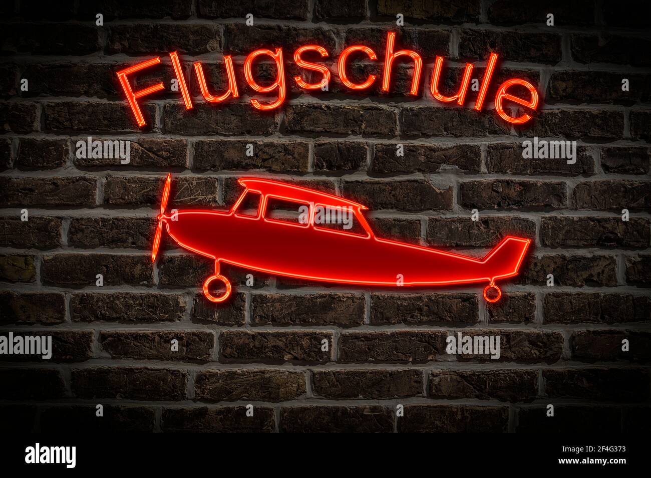 Leuchttreklame für eine Flugschule ein Flugzeug befindet sich in der Neon-Schrift Leuchtwerbung für eine Flugschule ein Flugzeug Ist Stockfoto