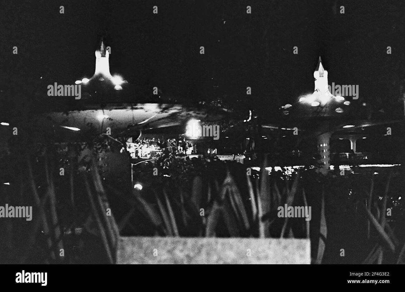 Nachtaufnahme des Nachtclubs Tropicana, mit Laub und Betonschirmen im Vordergrund und dem Arcos de Cristal im Hintergrund, Havanna, Kuba, 1964. Aus der Sammlung Deena Stryker Photographs. () Stockfoto
