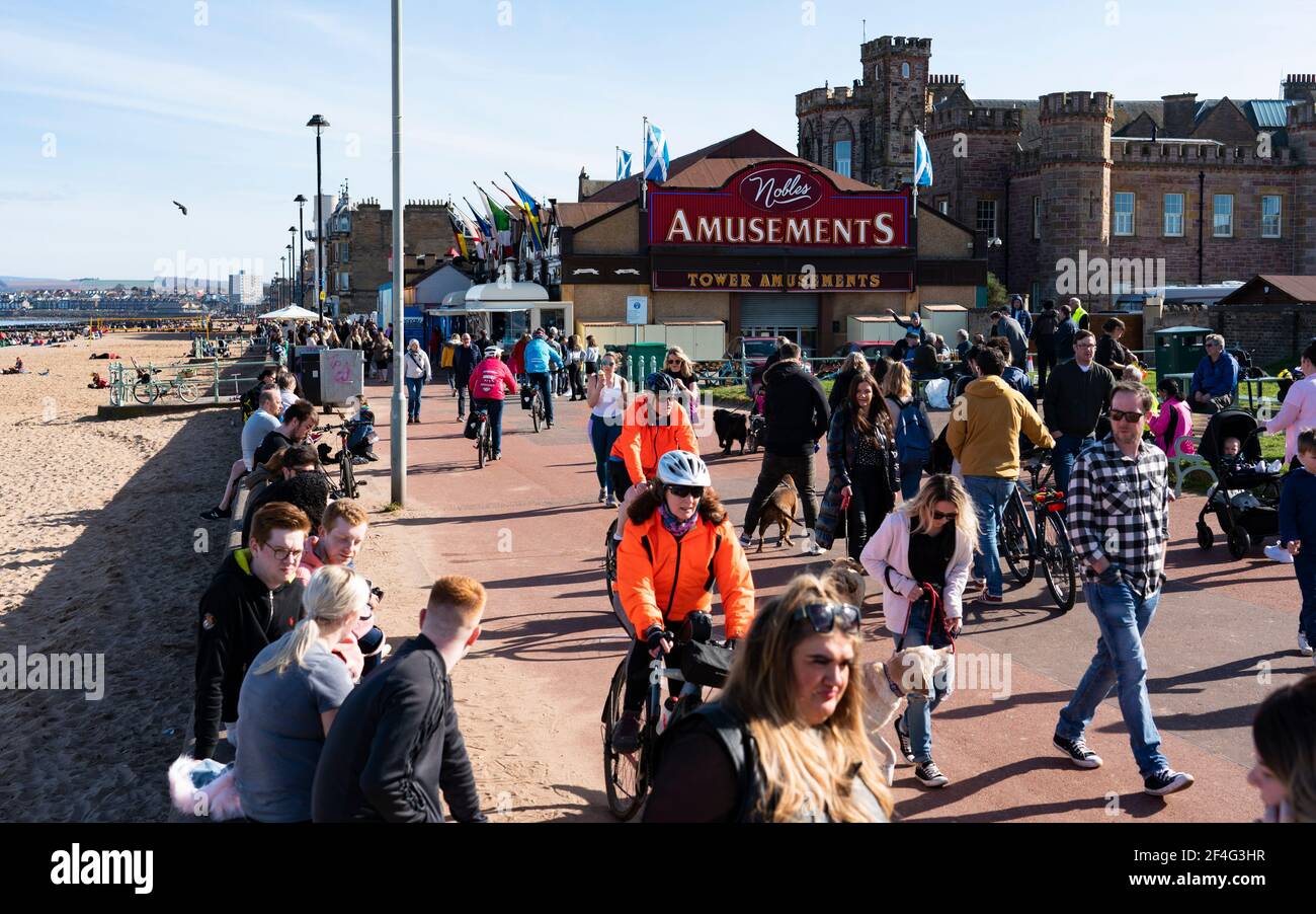 Portobello, Schottland, Großbritannien. 21. März 2021. Warme Temperaturen, blauer Himmel und Sonnenschein brachten die Massen an diesem Nachmittag zum beliebten Portobello Strand und zur Promenade. Trotz der andauernden covid-19 Lockdown wurde die Küste mit Mitgliedern der Öffentlichkeit gedrängt. Viele Cafés waren offen und boten Essen zum Mitnehmen an. Iain Masterton/Alamy Live News Stockfoto