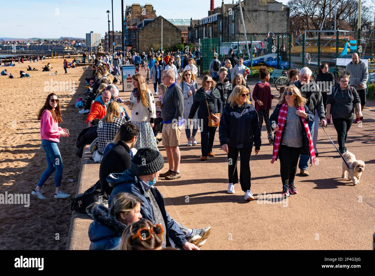 Portobello, Schottland, Großbritannien. 21. März 2021. Warme Temperaturen, blauer Himmel und Sonnenschein brachten die Massen an diesem Nachmittag zum beliebten Portobello Strand und zur Promenade. Trotz der andauernden covid-19 Lockdown wurde die Küste mit Mitgliedern der Öffentlichkeit gedrängt. Viele Cafés waren offen und boten Essen zum Mitnehmen an. Iain Masterton/Alamy Live News Stockfoto