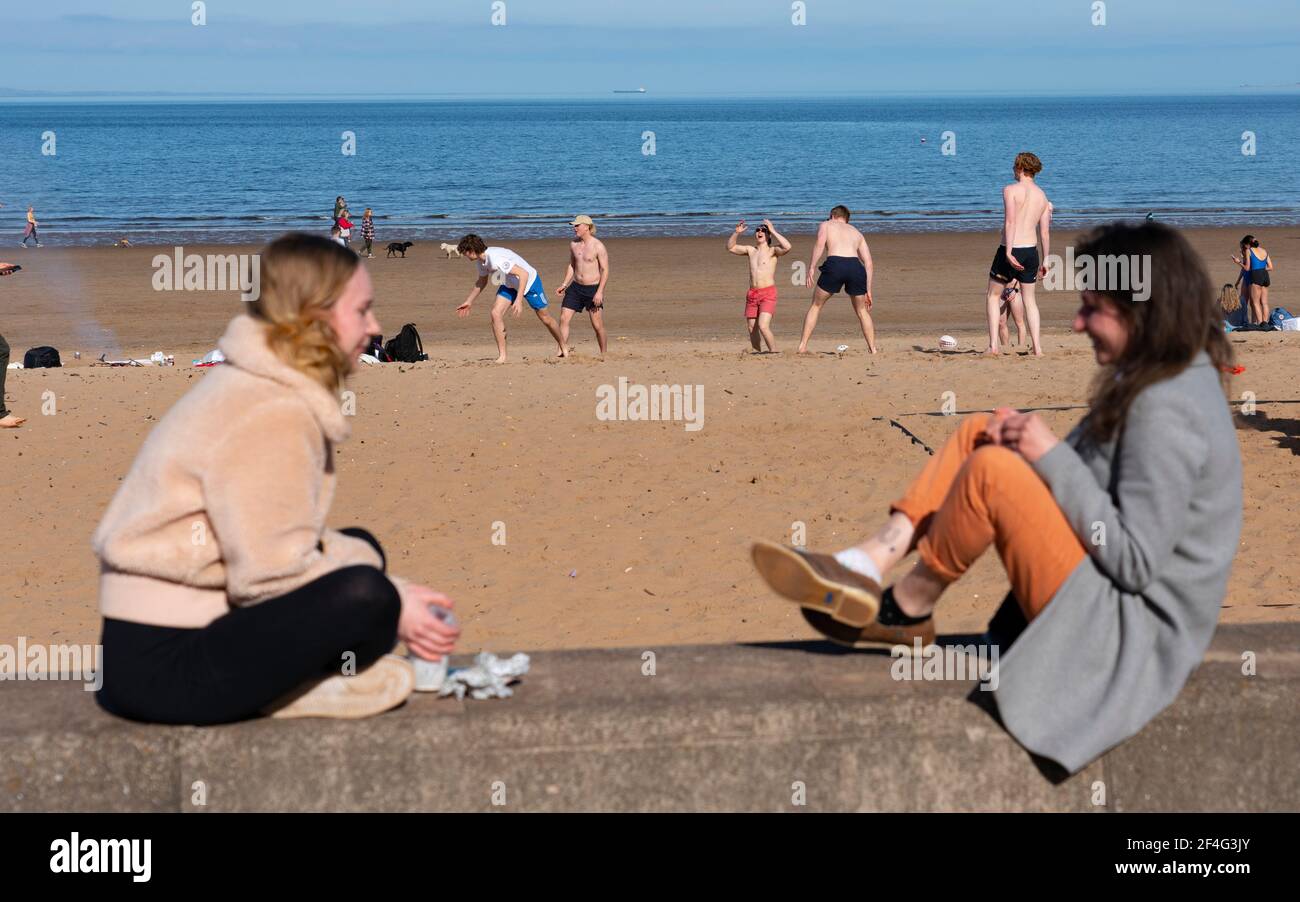 Portobello, Schottland, Großbritannien. 21. März 2021. Warme Temperaturen, blauer Himmel und Sonnenschein brachten die Massen an diesem Nachmittag zum beliebten Portobello Strand und zur Promenade. Trotz der andauernden covid-19 Lockdown wurde die Küste mit Mitgliedern der Öffentlichkeit gedrängt. Viele Cafés waren offen und boten Essen zum Mitnehmen an. Iain Masterton/Alamy Live News Stockfoto