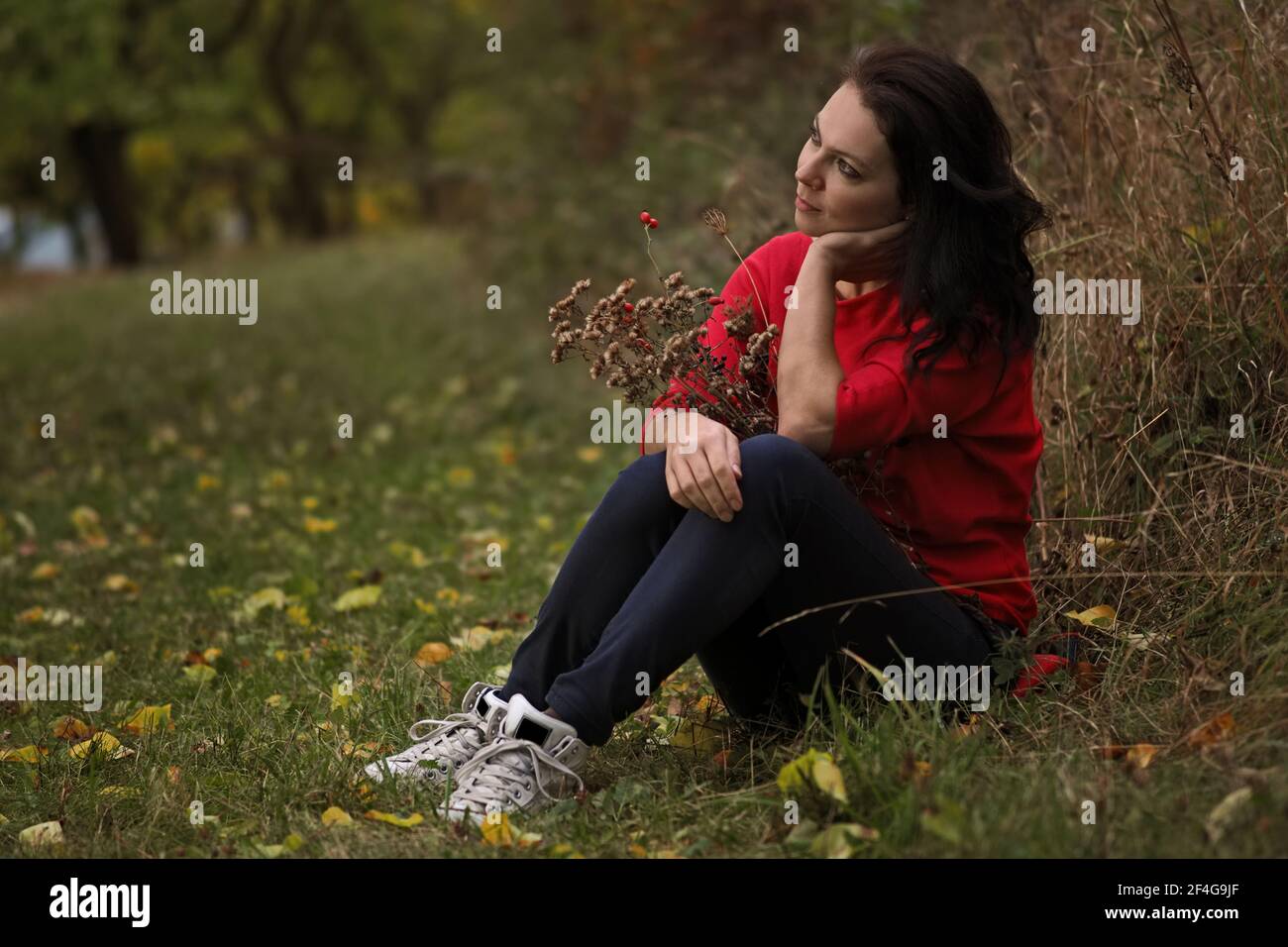Schöne 30-jährige Frau entspannt im Herbstpark Stockfoto