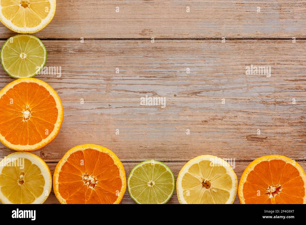 Orangen, Limetten und Zitronen Rutschen auf Holztisch Blick von oben. Wunderschön Hintergrund mit frischem Obst halb geschnitten.gesunde Ernährung Vitamin C.Sommer tropica Stockfoto