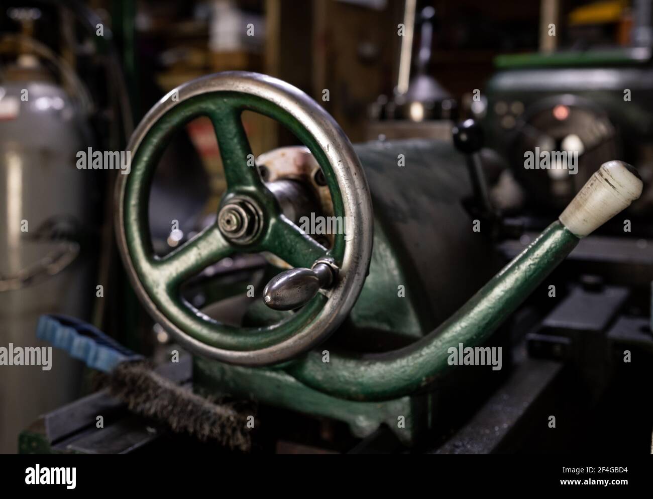 Alte grüne Drehmaschine Detail in der Werkstatt. Steuerrad mit Griff. Selektiver Fokus. Stockfoto