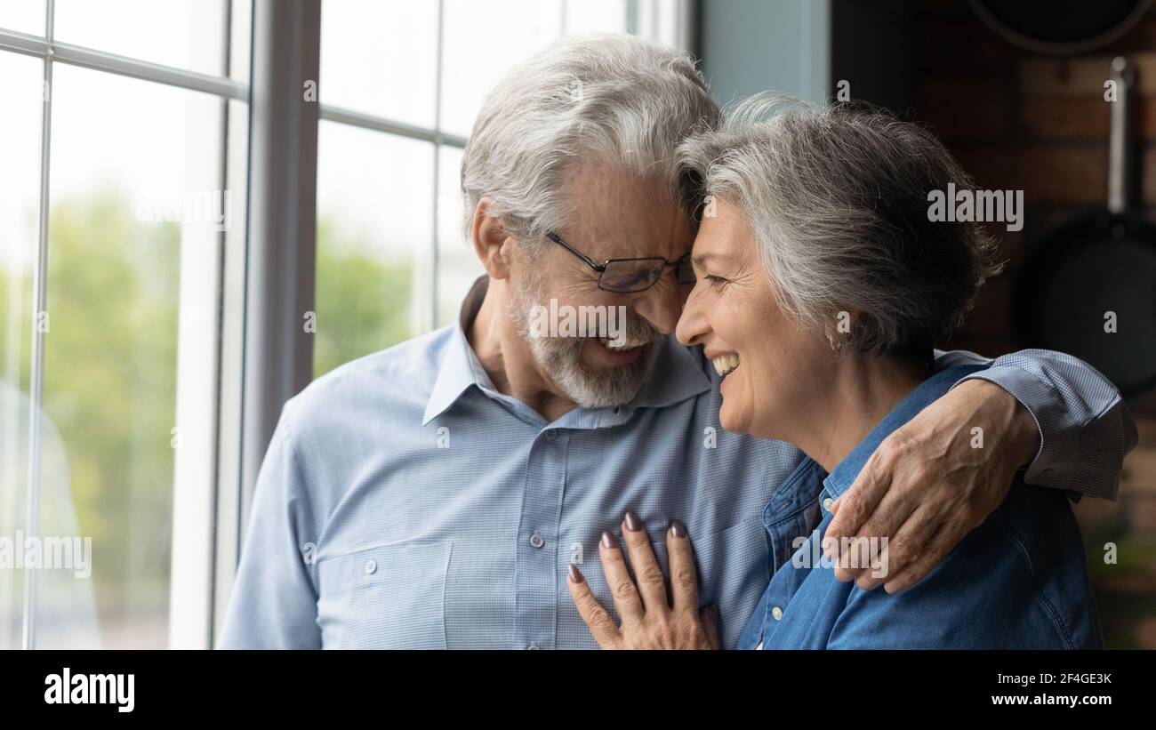 Liebevolle liebevolle Rentnerpaar haben Datum lachen kuscheln berühren Stirn Stockfoto