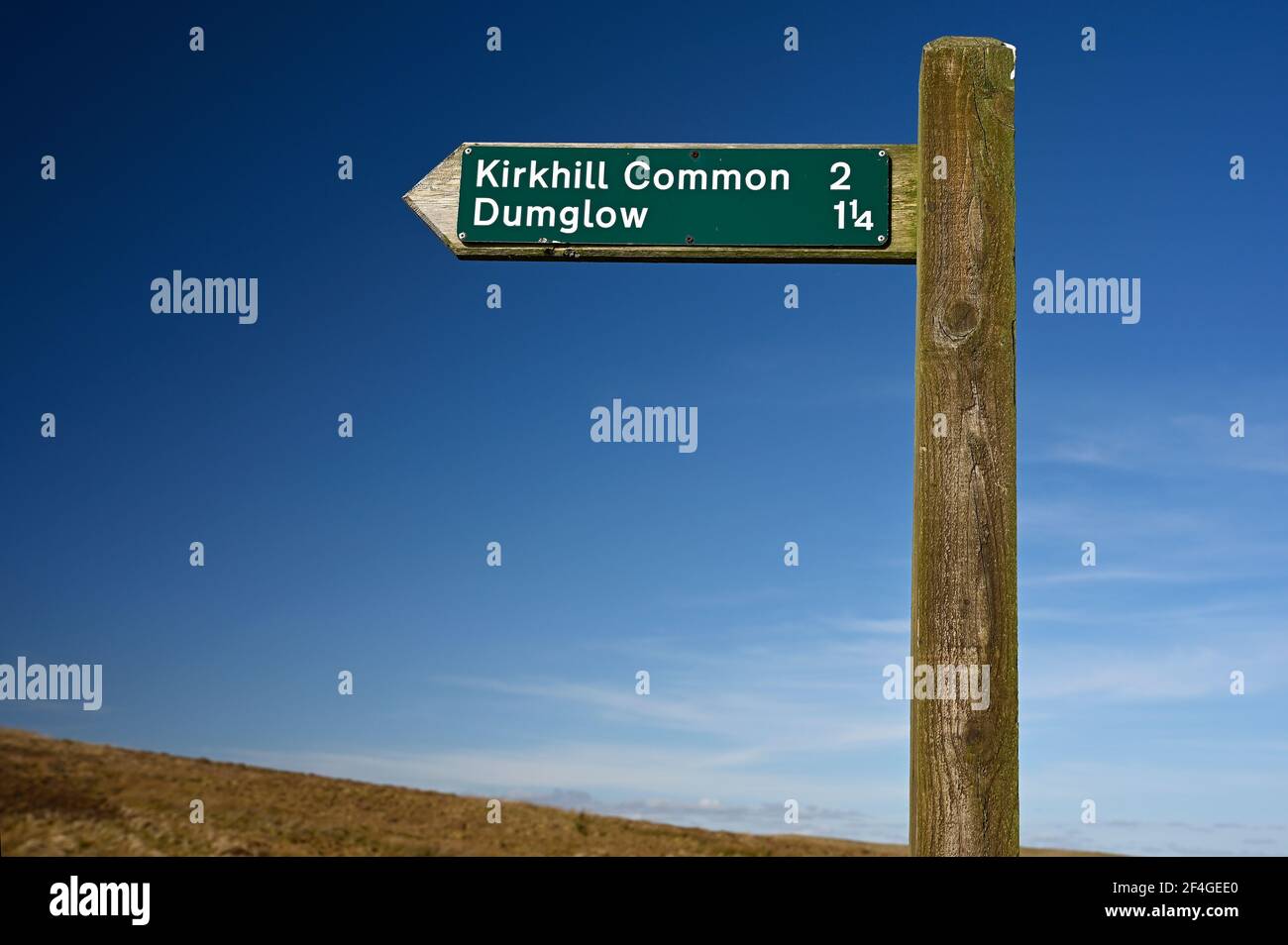 Öffentlicher Wegweiser für Kirkhill Common und Dumglow auf dem öffentlichen Wegweiser in Loch Glow, Fife, Schottland. Blauer Himmel, sonniger Tag, Hang des grasbewachsenen Hügels. Stockfoto