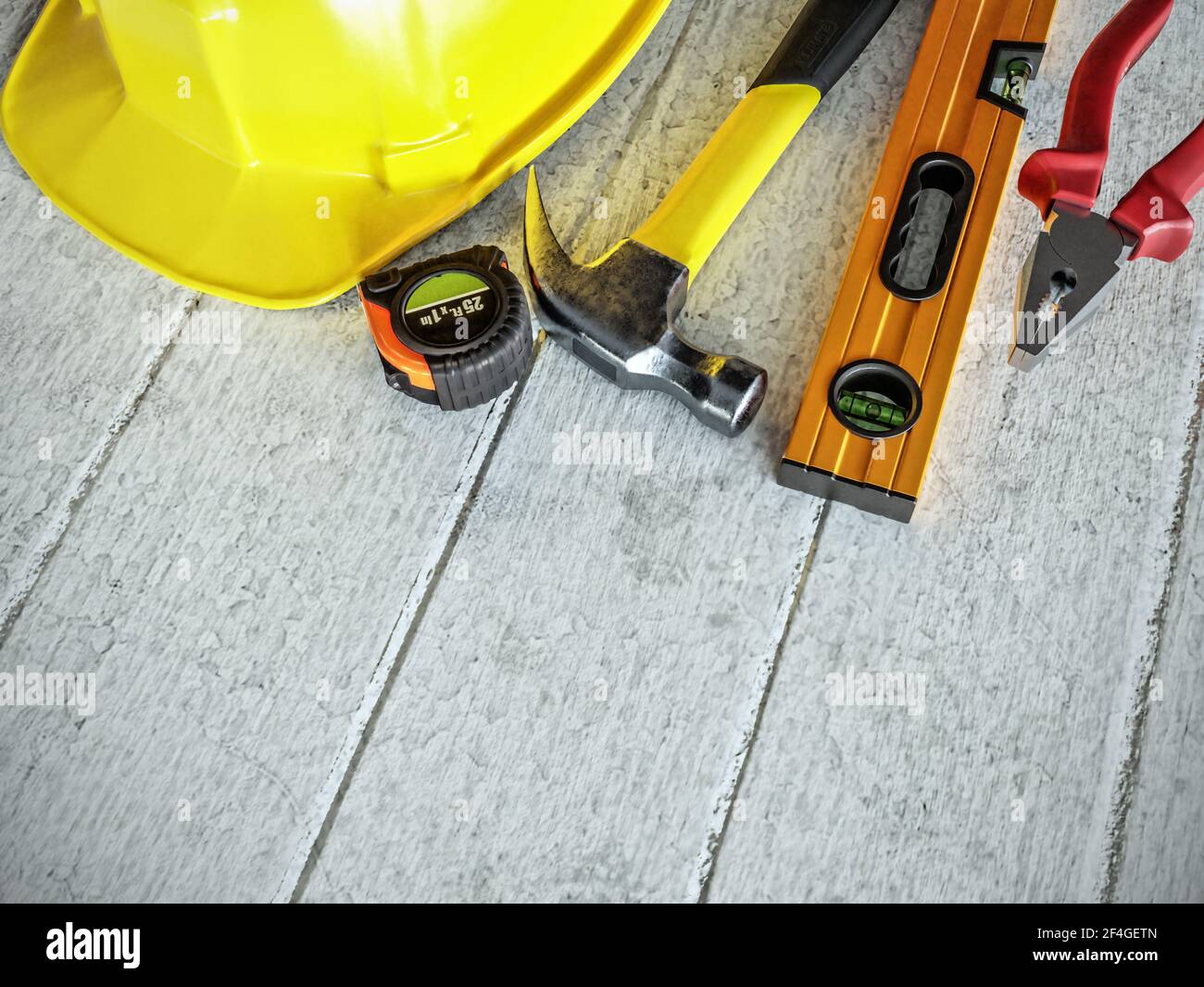 Grundlegende Konstruktionswerkzeuge und Arbeitskleidung auf Holzoberfläche mit platziert Copyspace Stockfoto