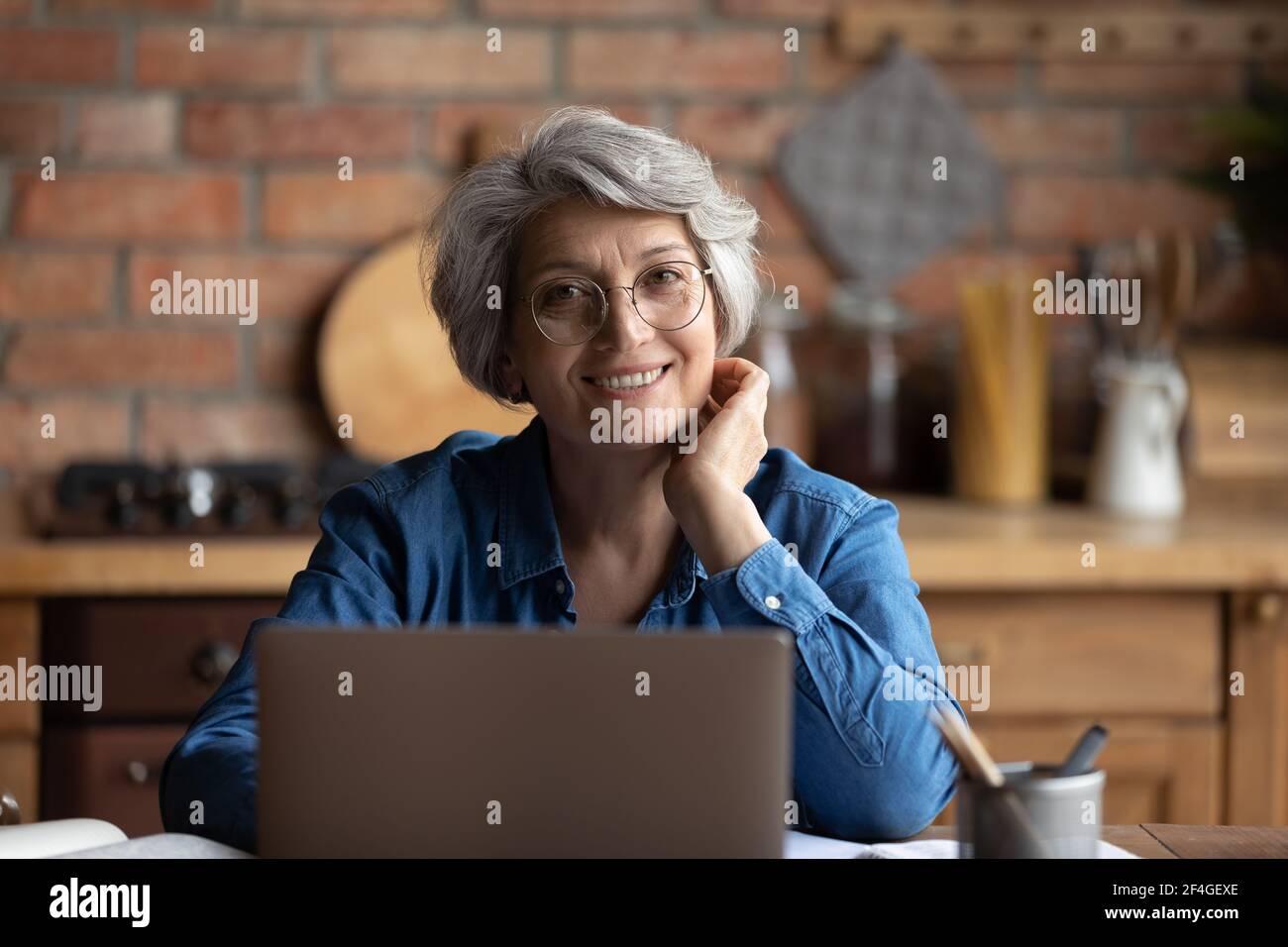 Glücklich Senior hispanic weiblich verwenden Laptop Arbeit Studie entfernt Stockfoto