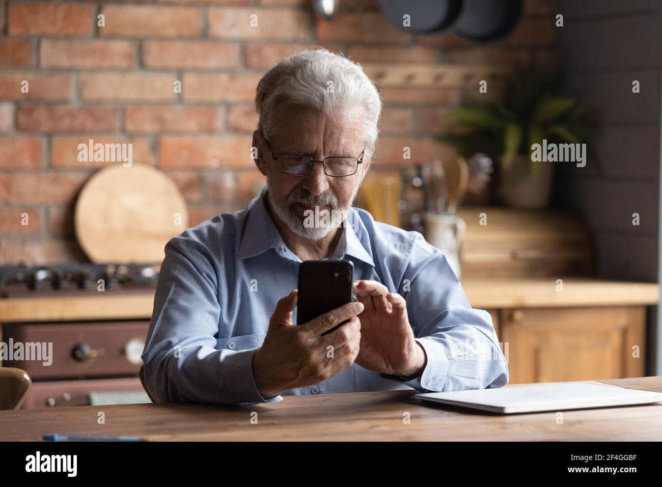 Fokussierter Rentner halten Handy-Rufnummer Stockfoto
