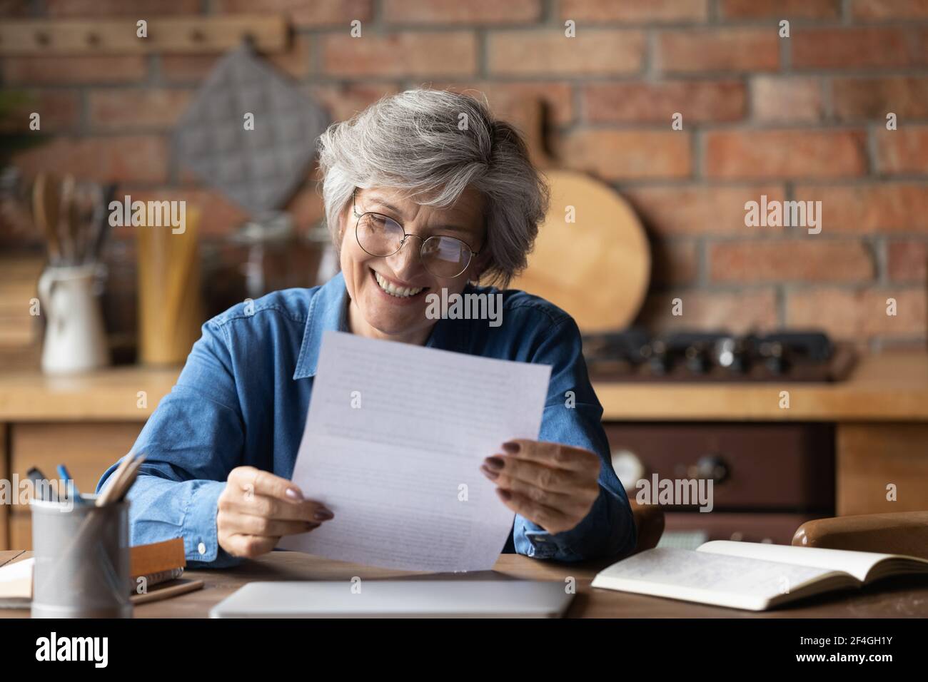 Eine gute alte latinerin las einen Brief aus Papier mit guten Nachrichten Stockfoto