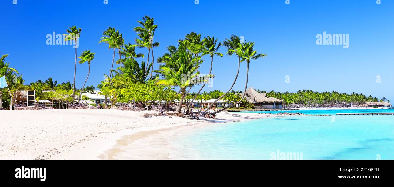 Panorama des schönen weißen Sandstrands in Cap Cana, Dominikanische Republik. Hintergrund für Urlaubsreisen. Sommer tropischer Strand mit grünen Palmen um. Stockfoto