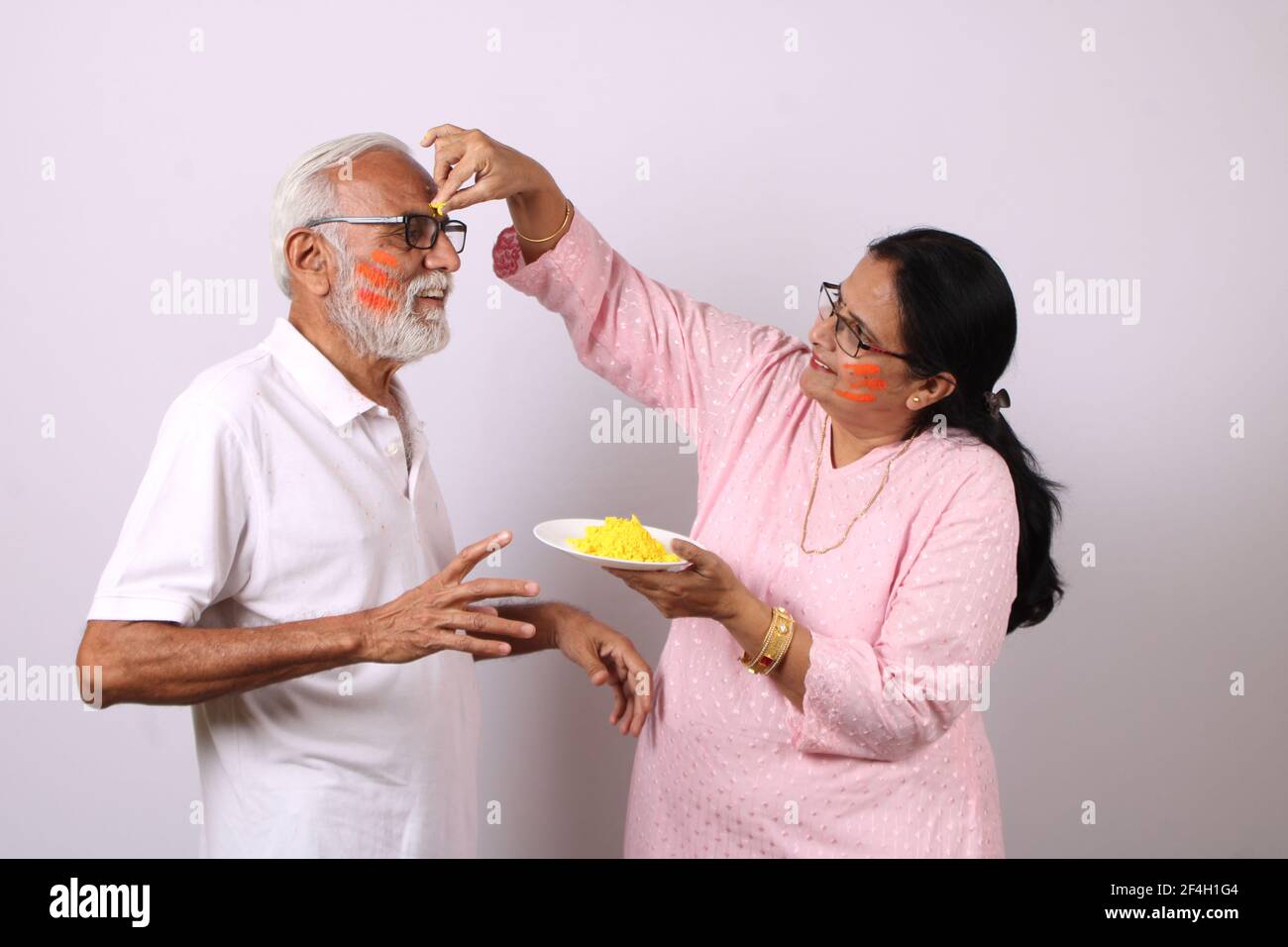 indisches Senioren- oder altes Paar, das holi mit Farbe feiert Stockfoto