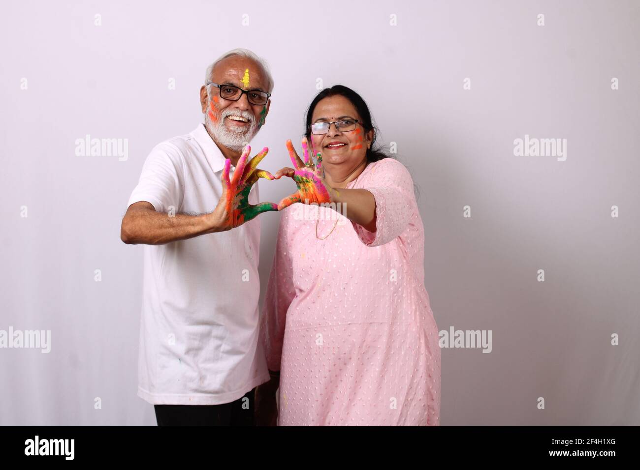 indisches Senioren- oder altes Paar, das holi mit Farbe feiert Stockfoto