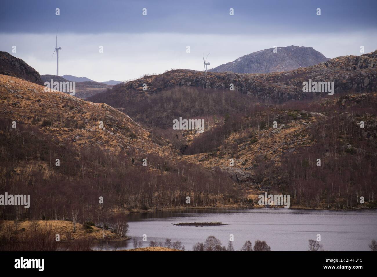 Wunderschöne norwegenberge und blauer See mit Windmühlen in der Hintergrund - Nachhaltige Zukunft und Konzept für saubere Energie Stockfoto