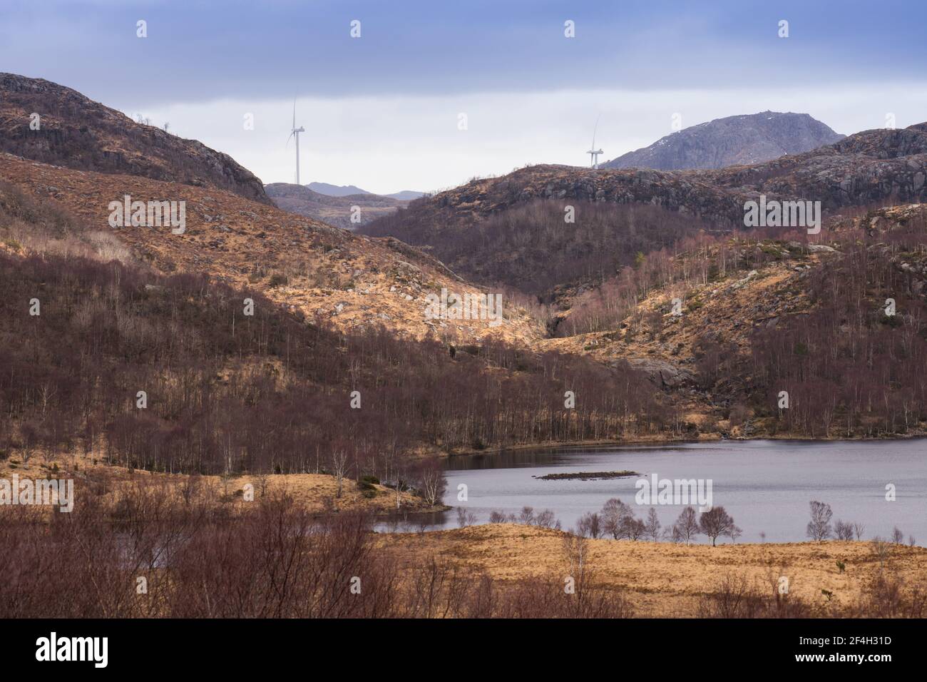 Wunderschöne norwegenberge und blauer See mit Windmühlen in der Hintergrund - Nachhaltige Zukunft und Konzept für saubere Energie Stockfoto