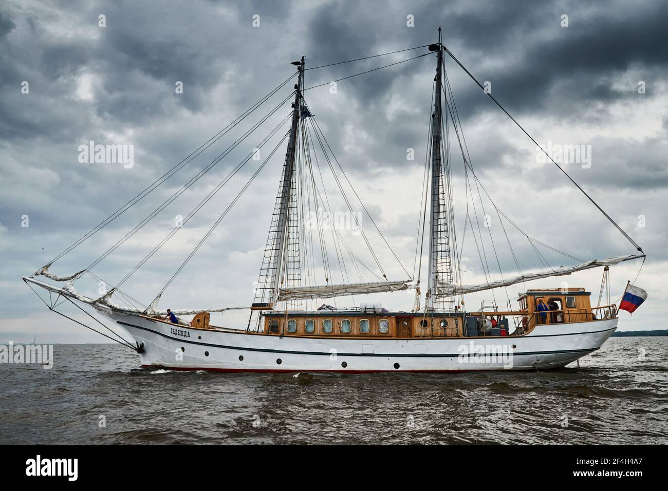 Russland, St.Petersburg, 31. August 2020: Antike Segelfrigate von weißer Farbe zum Meer, der sinkende Sturmhimmel, Segel sind abgesenkt, Masten und Seile Stockfoto
