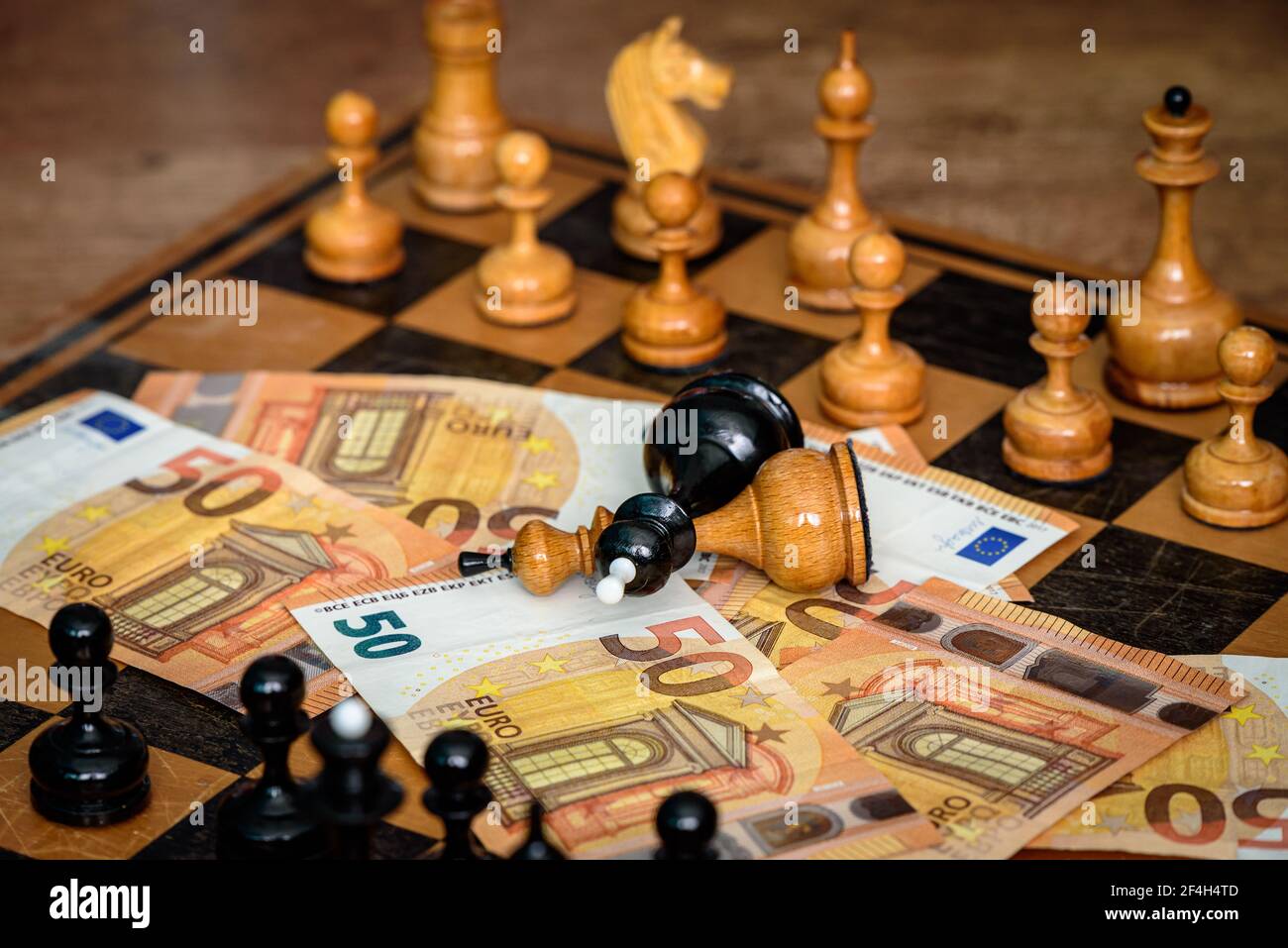 Ein Schachtisch mit Figuren und echtem Geld, das will Als Gewinn gespielt oder gewonnen werden Stockfoto