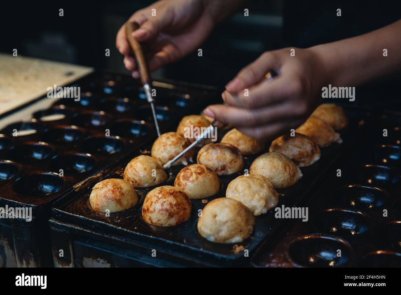 Frau macht Takoyaki, japanisches Street Food Stockfoto