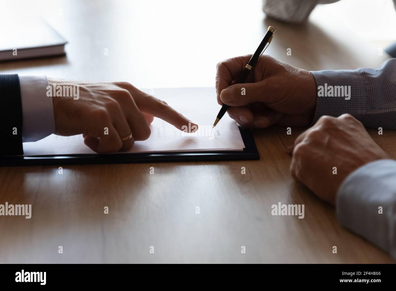Nahaufnahme eines älteren Mannes, der beim Treffen den Vertrag unterzeichnet Stockfoto