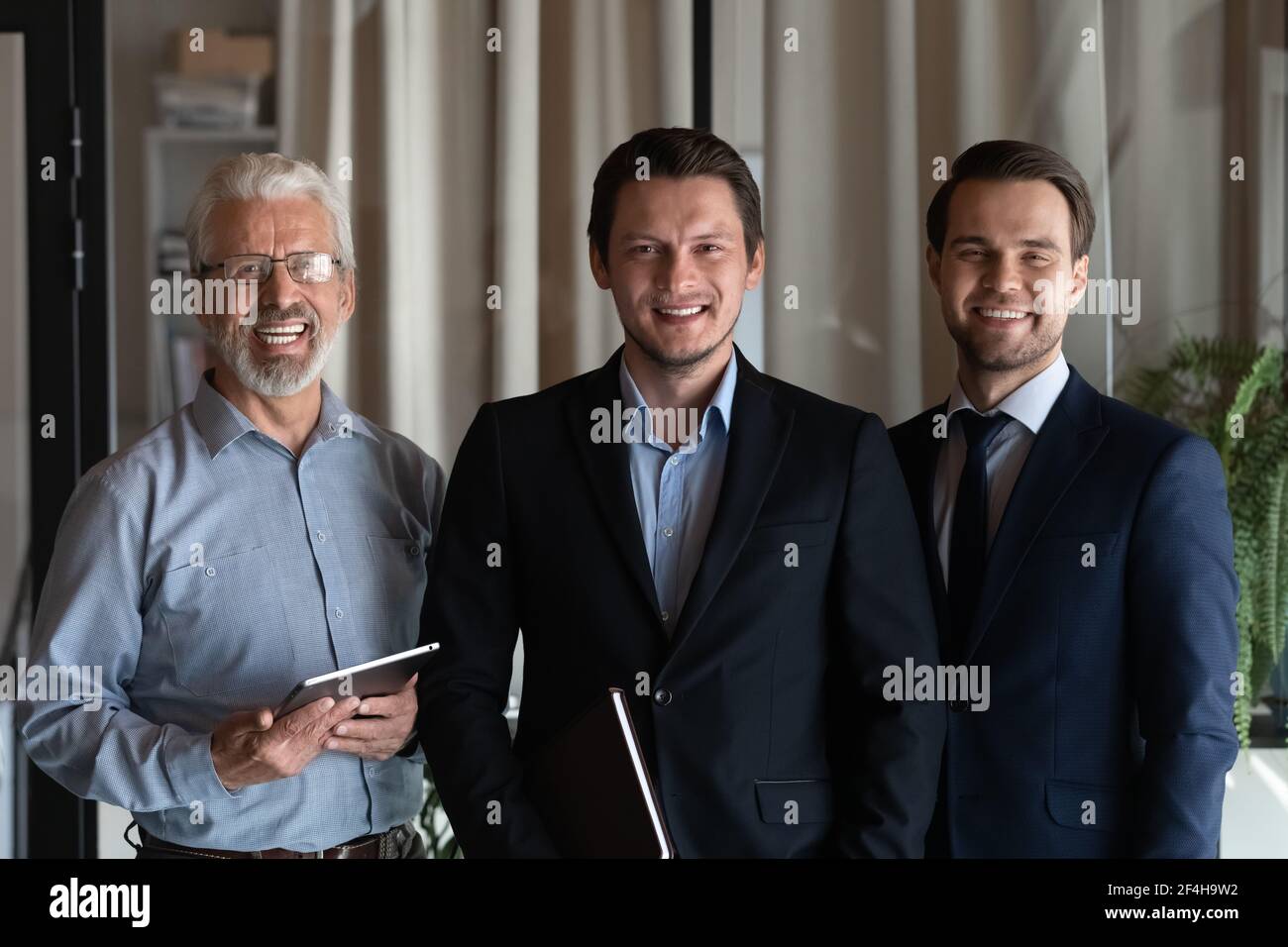 Portrait von lächelnden männlichen Mitarbeitern zeigen Einheit Stockfoto