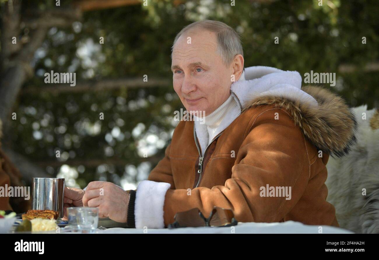 Tuva, Russland. März 2021, 21st. Der russische Präsident Wladimir Putin macht eine Mittagspause während eines Wochenendausflugs mit Verteidigungsminister Sergei Shoigu im russischen sibirischen Taiga-Wald am 21. März 2021 in Tuwa, Russland. Quelle: Planetpix/Alamy Live News Stockfoto