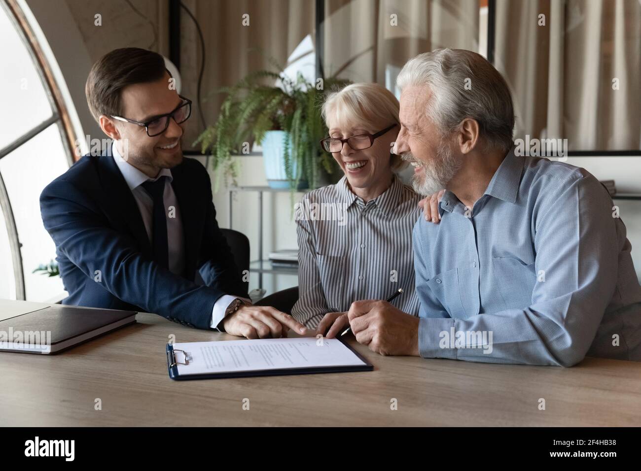 Aufgeregt reifes Paar Vertrag mit makler unterzeichnen Stockfoto