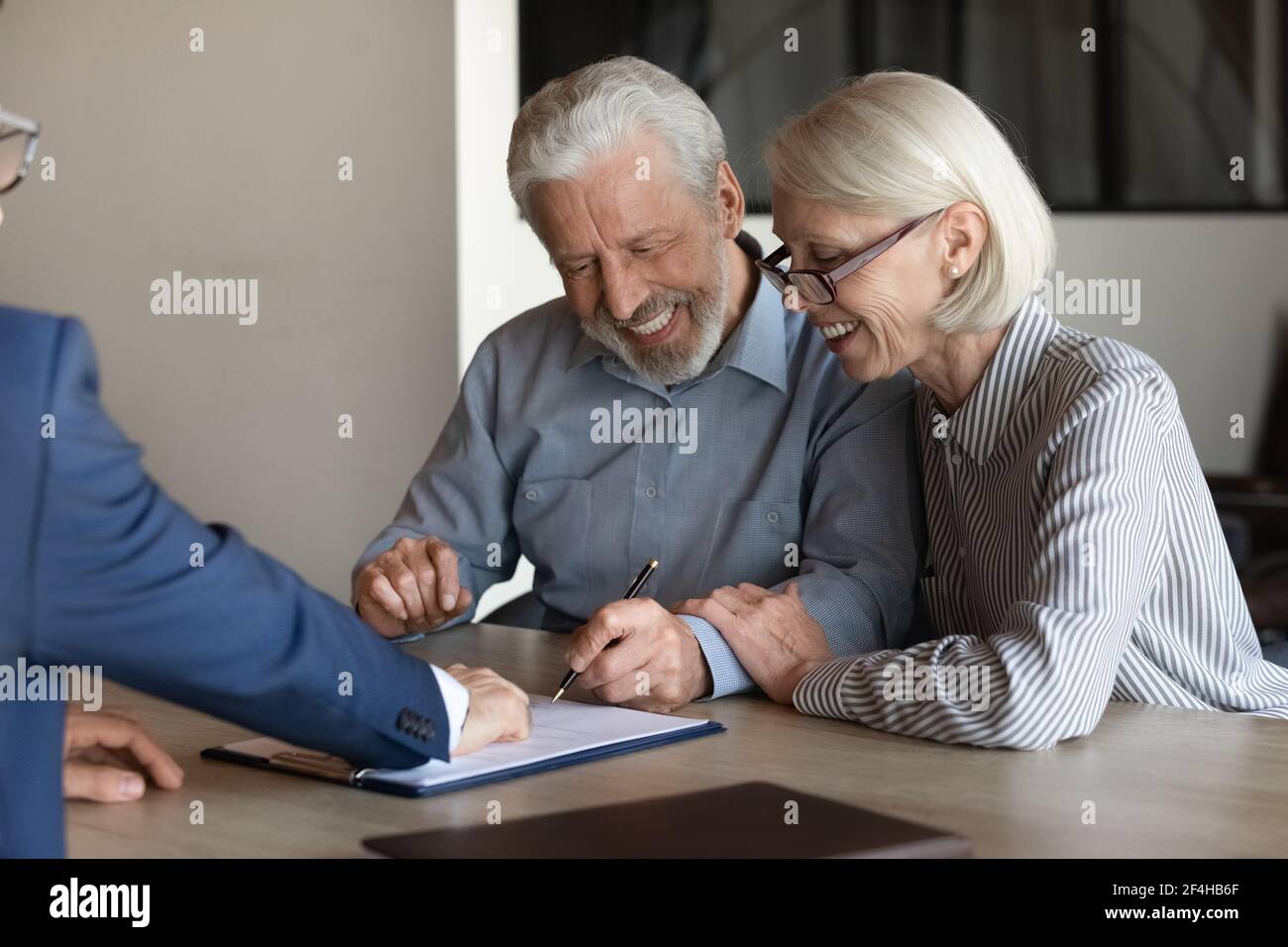 Aufgeregt ältere paar Kunden schließen Deal bei der Sitzung Stockfoto