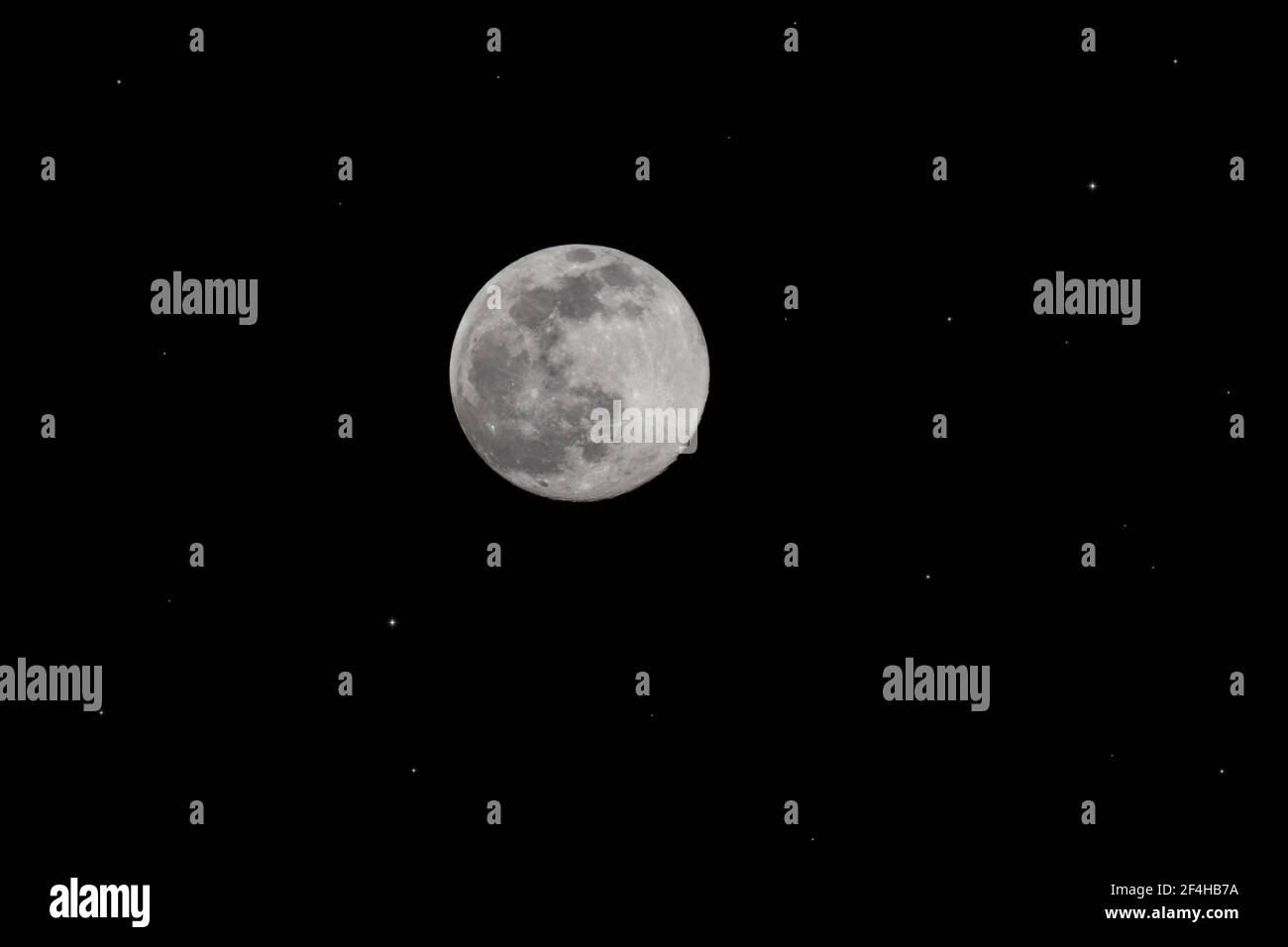 Die Mondphase wird einen Tag vor Vollmond wuchtiger Mit einem sternenbeleuchteten Hintergrund Stockfoto