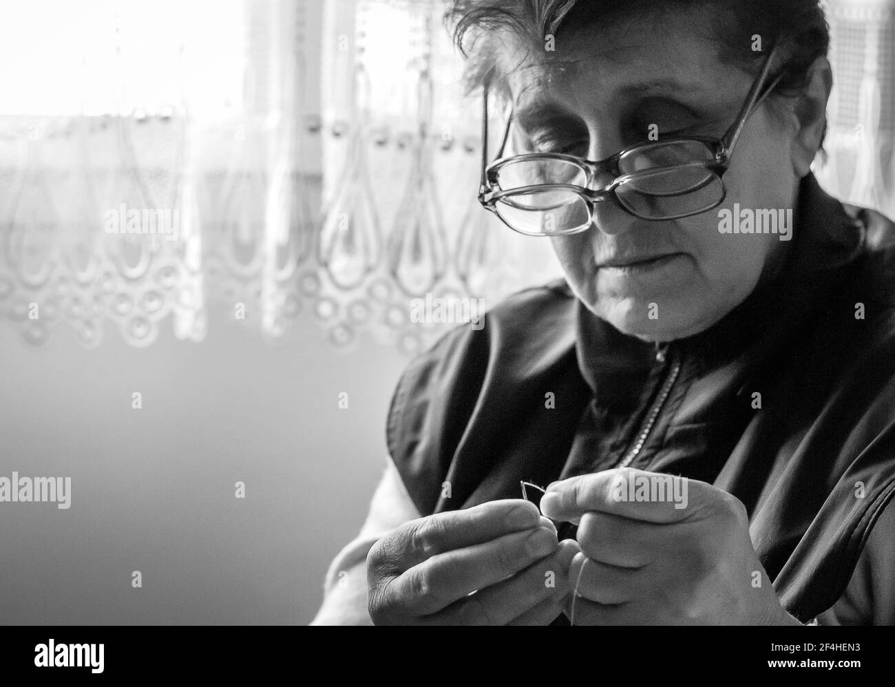 Schwarz-Weiß-Foto einer älteren Frau, die ein Nadel Stockfoto