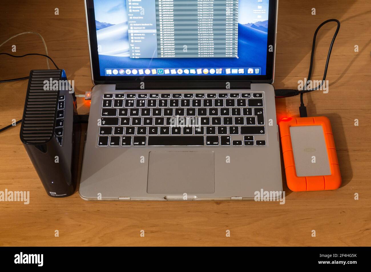 Laptop-Computer mit zwei verschiedenen externen Festplatten angeschlossen. Daten werden gesichert. Stockfoto