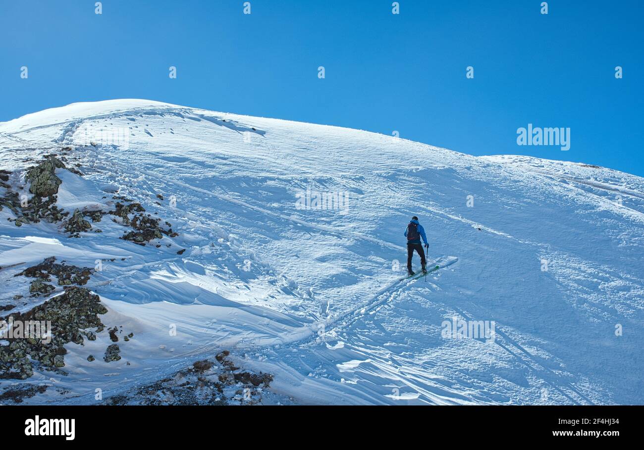 Nach einem langen Aufstieg an einem herrlichen Wintertag den Gipfel erreichen. Stockfoto