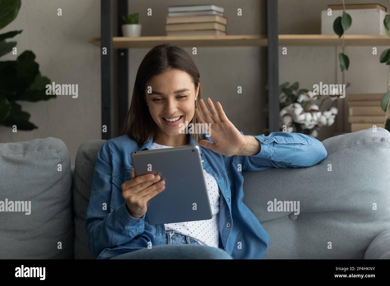 Nahaufnahme lächelnde Frau winkt Hand, halten Computer Tablet Stockfoto