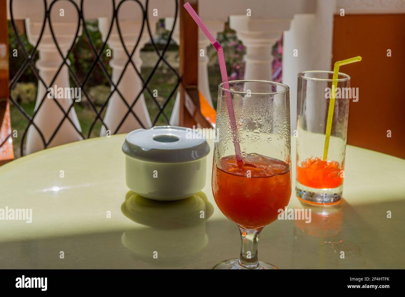 Cocktails und Fruchtsaft in Gläsern neben einem Aschenbecher Weißer Tisch in einem Restaurant Stockfoto