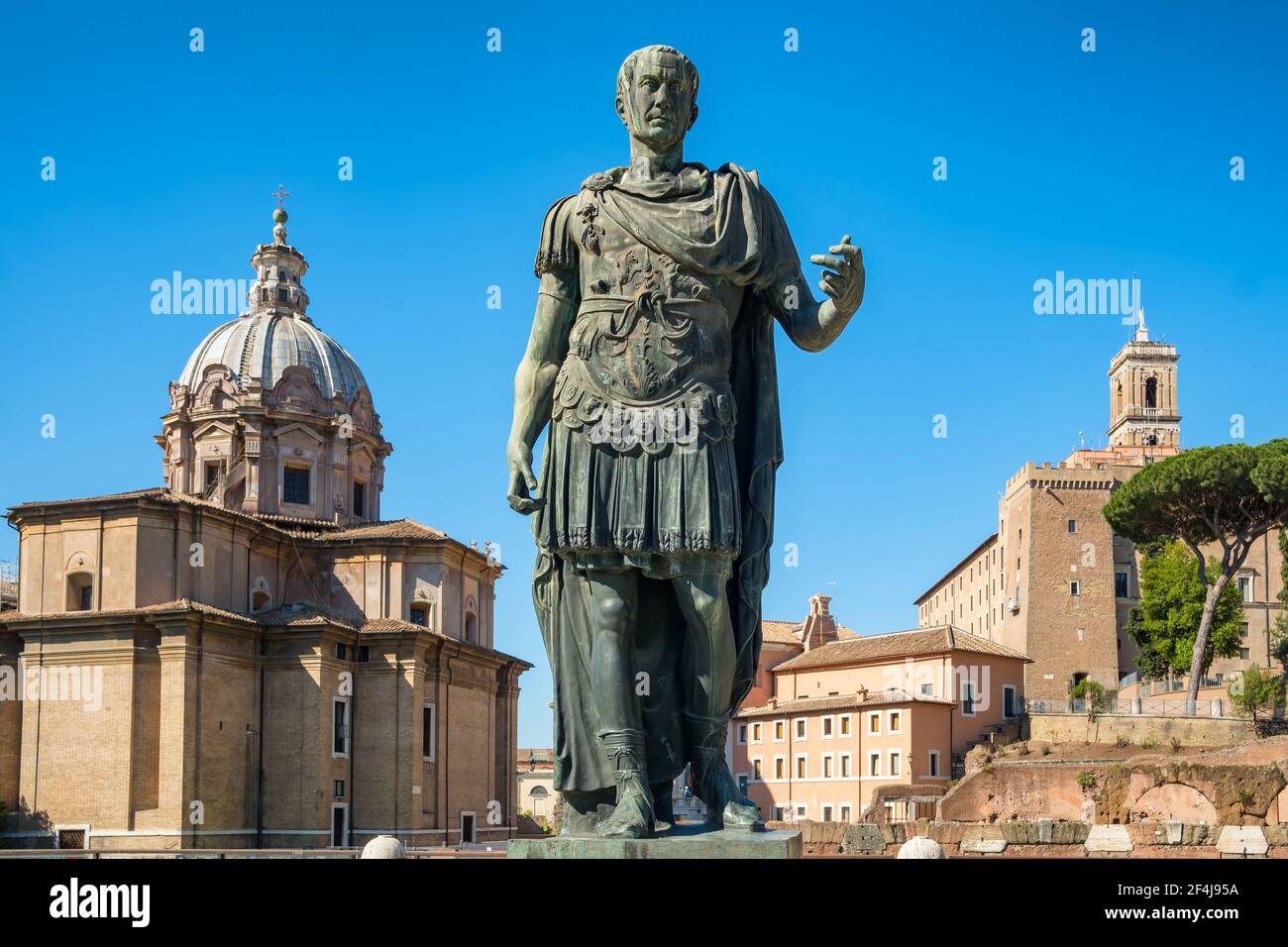 Alte Statue von Julius Caesar in Rom mit Santi Luca E Martina Kirche im Hintergrund Stockfoto