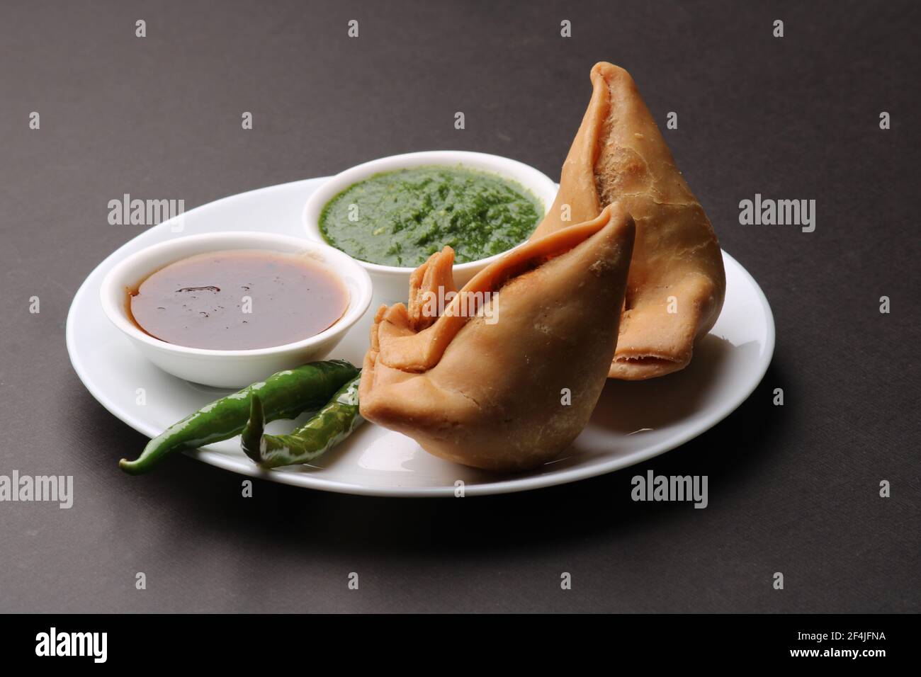 Indische Snack hausgemachte würzige und köstliche Samosa serviert mit grünen, Tamarinde Chutney. Stockfoto