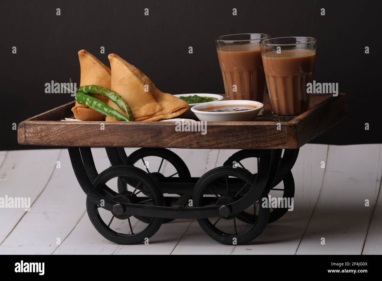 Indische Snack hausgemachte würzige und köstliche Samosa serviert mit grünen, Tamarinde Chutney Schneiden Masala Tee, Chai, Stockfoto