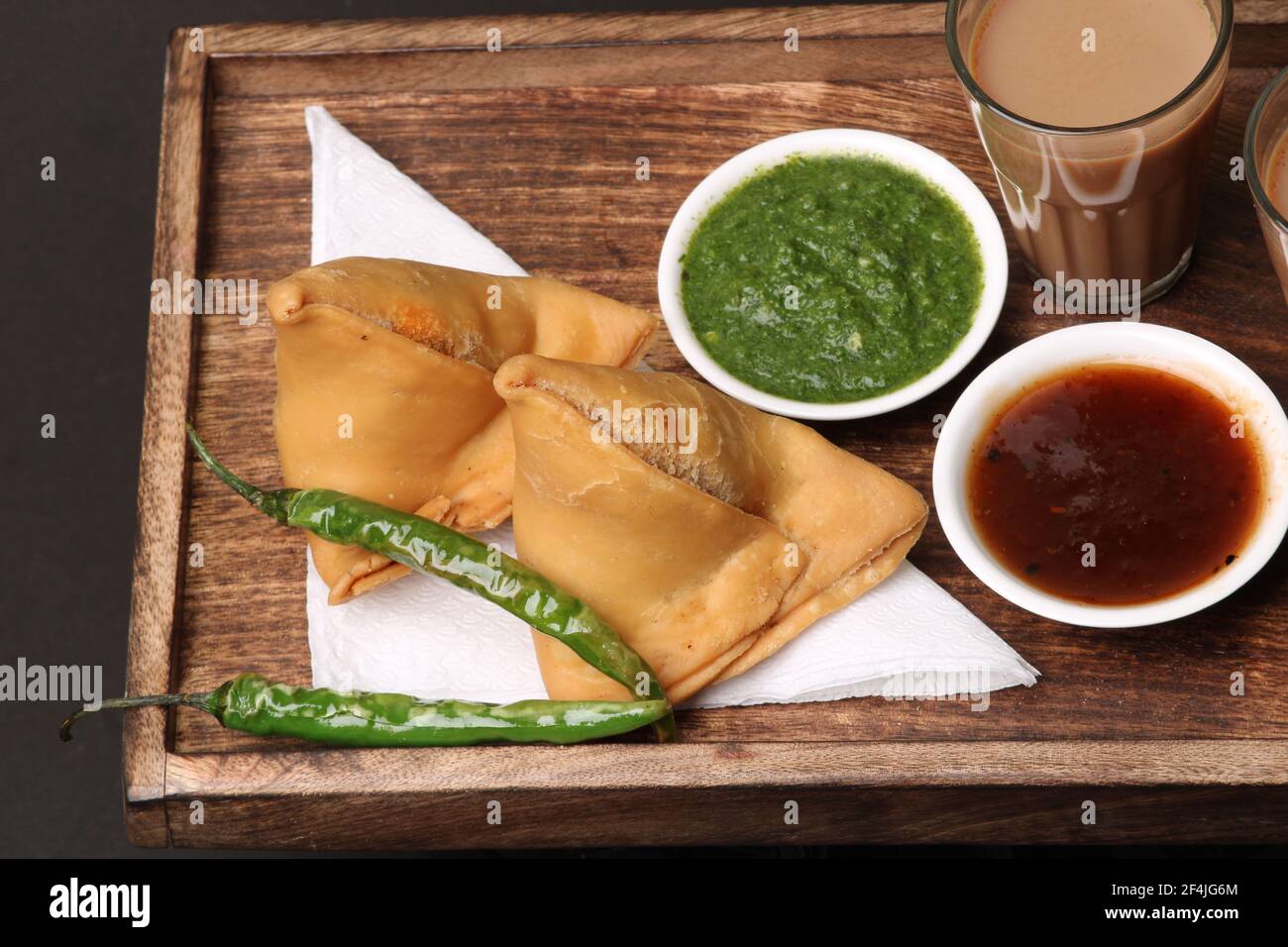 Indische Snack hausgemachte würzige und köstliche Samosa serviert mit grünen, Tamarinde Chutney Schneiden Masala Tee, Chai, Stockfoto