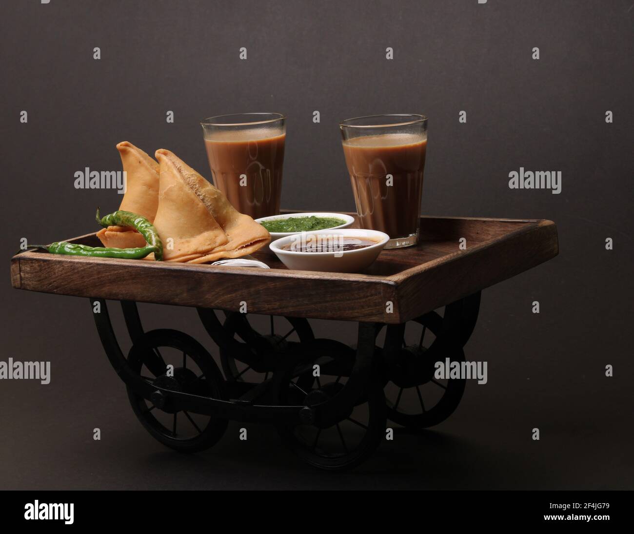 Indische Snack hausgemachte würzige und köstliche Samosa serviert mit grünen, Tamarinde Chutney Schneiden Masala Tee, Chai, Stockfoto