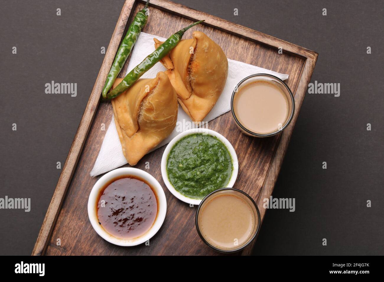 Indische Snack hausgemachte würzige und köstliche Samosa serviert mit grünen, Tamarinde Chutney Schneiden Masala Tee, Chai, Stockfoto