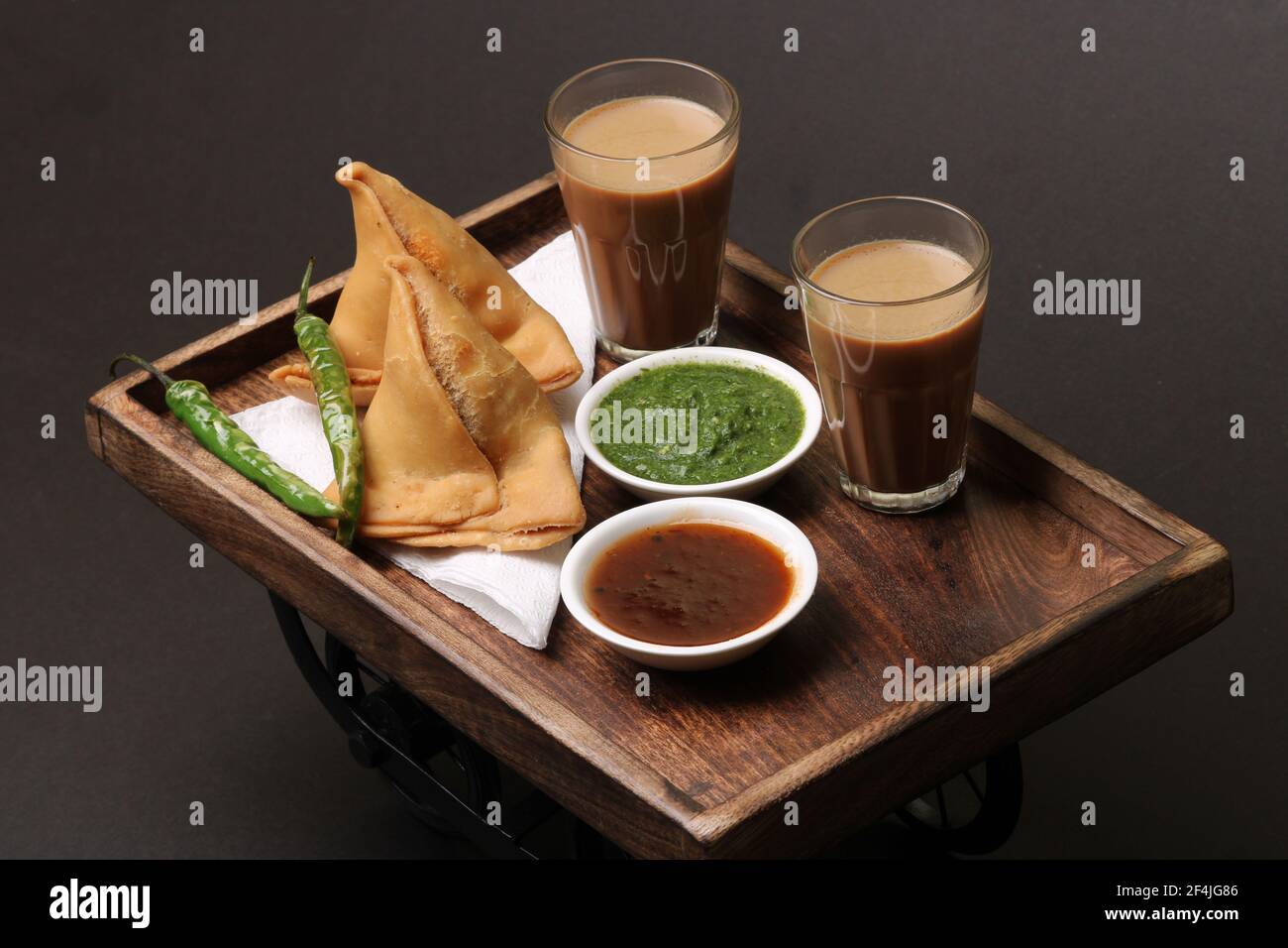 Indische Snack hausgemachte würzige und köstliche Samosa serviert mit grünen, Tamarinde Chutney Schneiden Masala Tee, Chai, Stockfoto