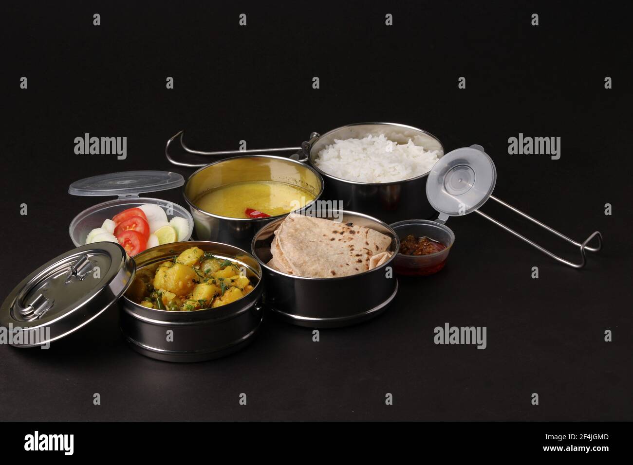 Typische Edelstahl Lunch Box oder Tiffin mit Maharashtrian Food-Menü Chapati ODER Roti, Plain Dal Tadka, White Rice Potato Sabji mit Salat und Pick Stockfoto