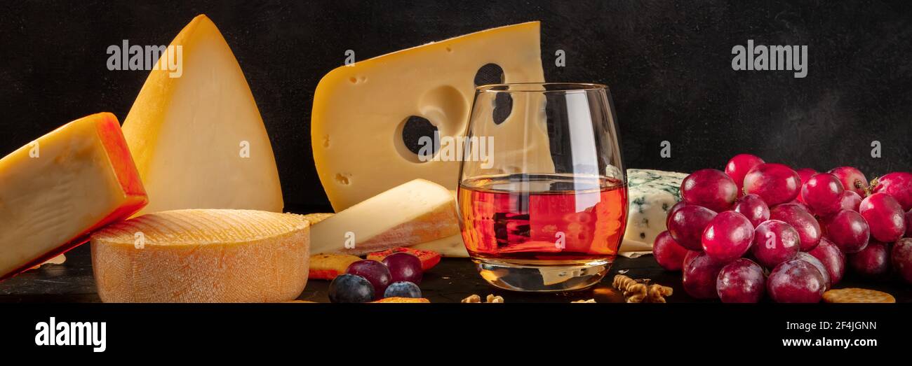 Käse, Wein und Trauben Panorama auf schwarz Stockfoto