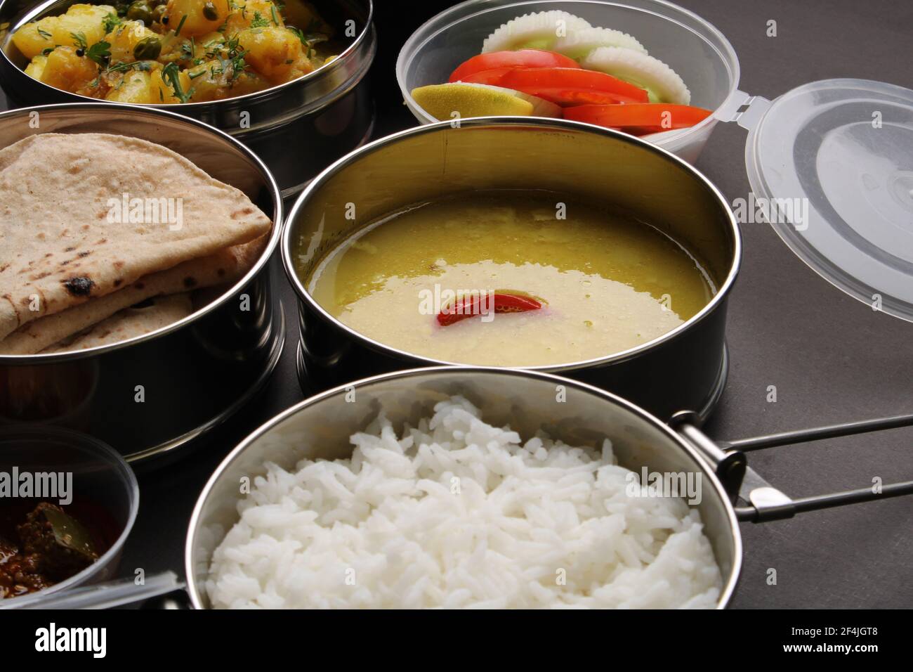 Typische Edelstahl Lunch Box oder Tiffin mit Maharashtrian Food-Menü Chapati ODER Roti, Plain Dal Tadka, White Rice Potato Sabji mit Salat und Pick Stockfoto