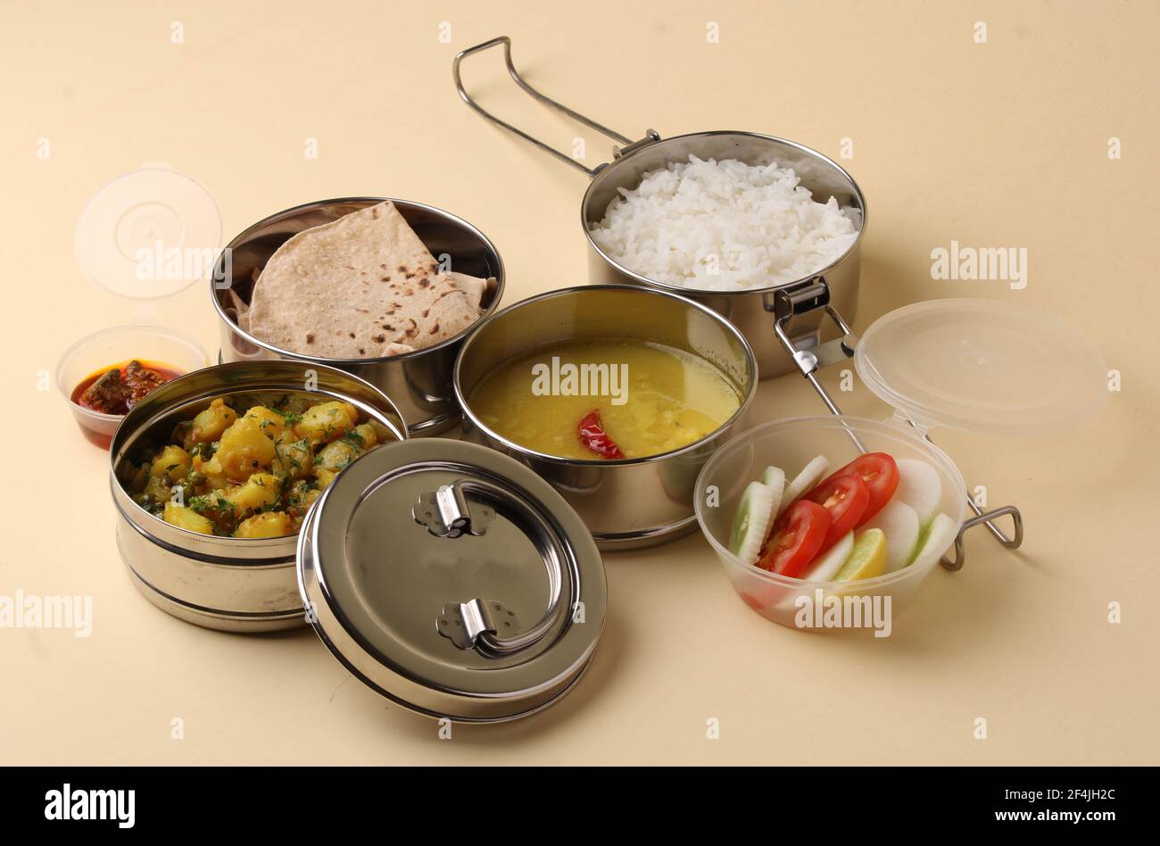 Typische Edelstahl Lunch Box oder Tiffin mit Maharashtrian Food-Menü Chapati ODER Roti, Plain Dal Tadka, White Rice Potato Sabji mit Salat und Pick Stockfoto