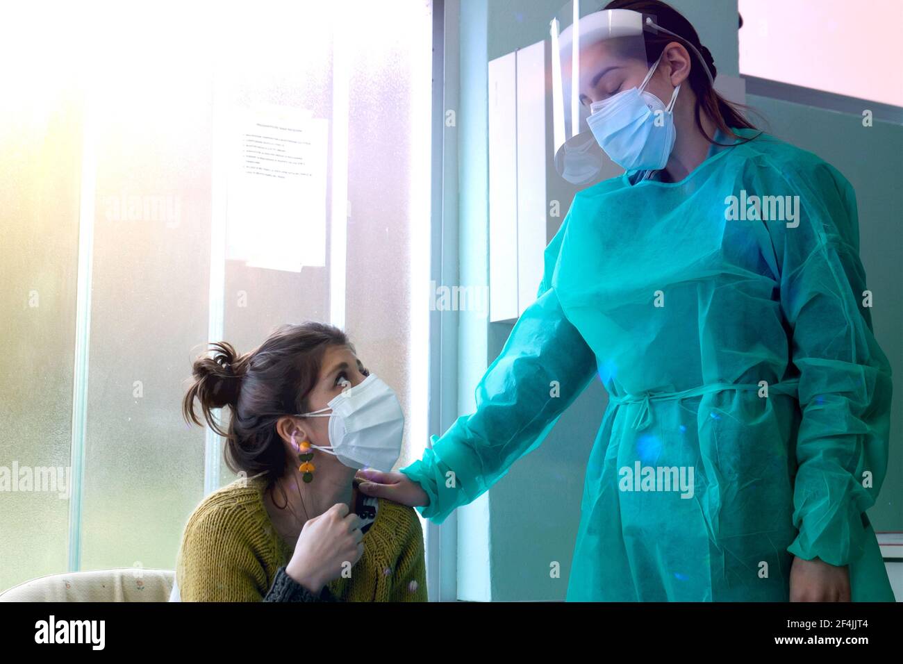 Gesundheitsarbeiter mit Sicherheitsvorrichtungen tröstet eine Person, die aufgrund des Coronavirus in Not und Angst ist. Stockfoto