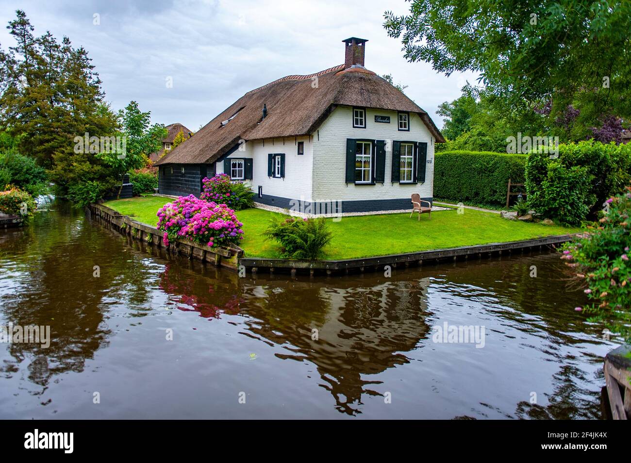 Giethoorn, Niederlande - 6. Juli 2019: Typisches holländisches Dorfhaus mit traditionellem Dach im Dorf Giethoorn, Niederlande Stockfoto