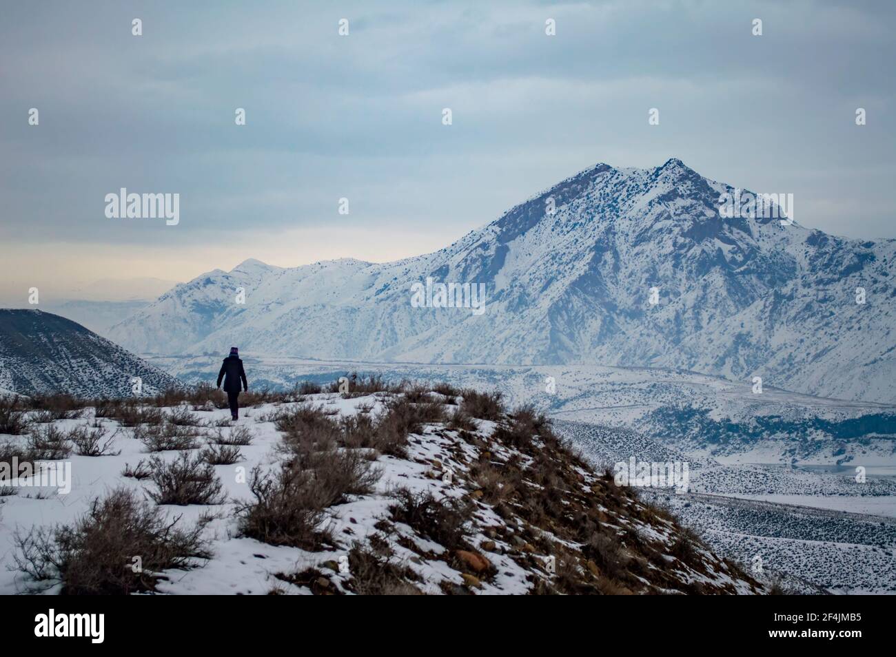 Unbekannte Person, die am Ufer des Azat-Stausees in Armenien entlang wandert, mit dem Berg Yeranos im Hintergrund Stockfoto